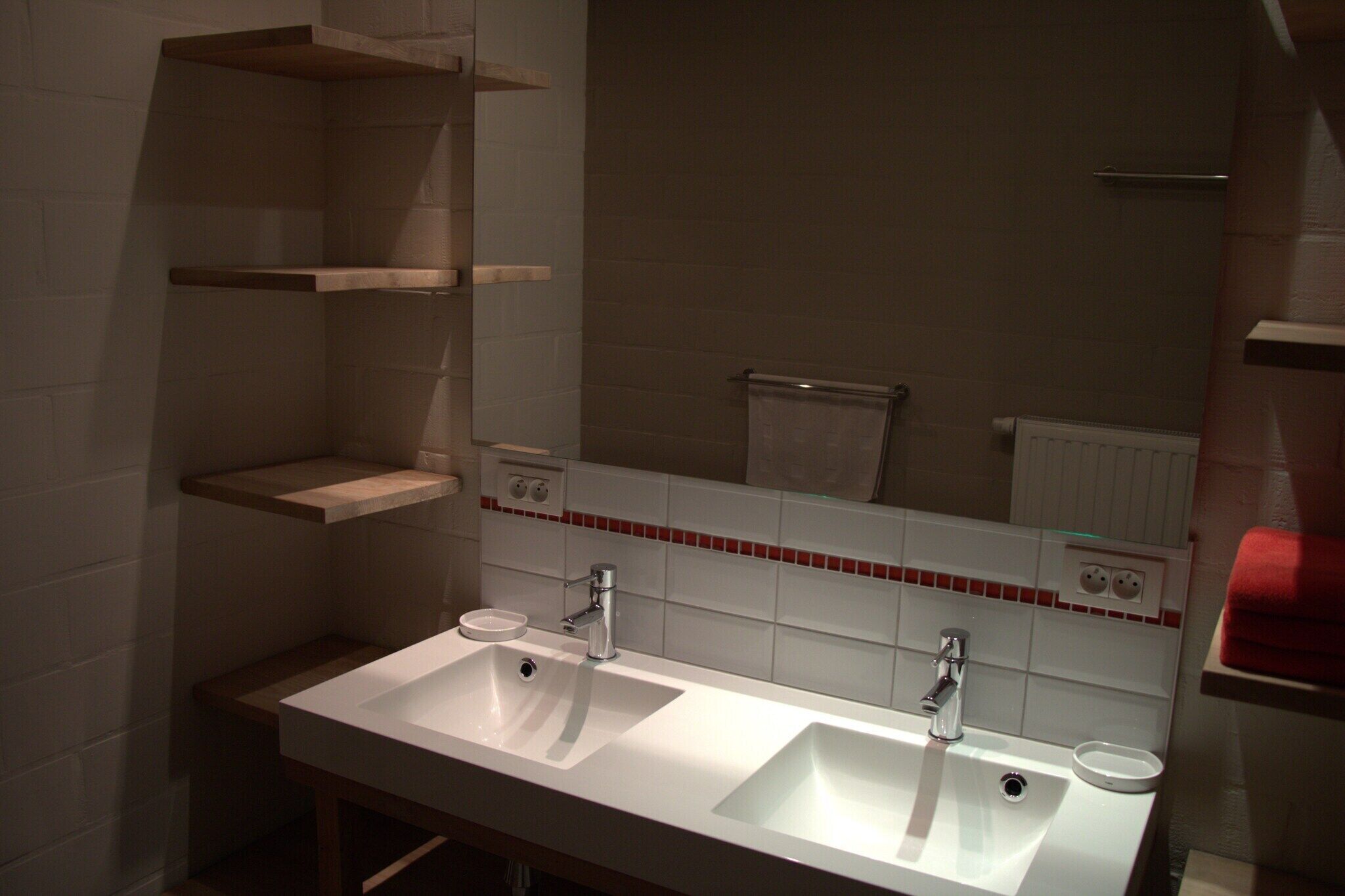 Ein Badezimmer mit zwei Waschbecken, einem Spiegel und einem Handtuchhalter.