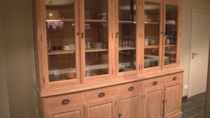 A wooden cabinet with multiple glass doors and drawers, likely used for storage in a home or office setting. - Countryside holiday home (Gijverinkhove)