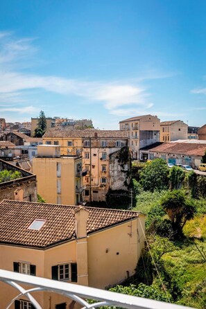 Una zona residencial con tejados de teja anaranjada, edificios de varios pisos y abundante vegetación.
