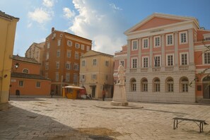 A historic square with cobblestone pavement, a statue, and classical architecture. - Spianada Dimora Corfu (Corfu)