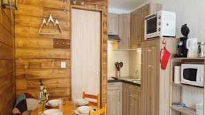 Una cocina acogedora con armarios de madera, microondas y cafetera.
