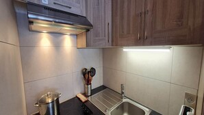 Una cocina moderna con estufa de acero inoxidable, un fregadero y armarios de madera.