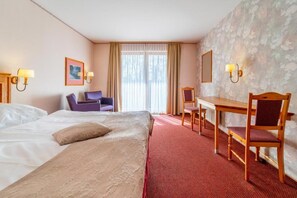 A hotel room with a bed, a desk, two chairs, and a large window with curtains. - Hotel Heiderhof by Belvilla- Double Room (Obersteinebach)