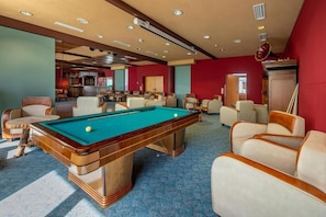 A pool table in a room with multiple chairs and a bar area in the background. - Hotel Heiderhof by Belvilla- Double Room (Obersteinebach)