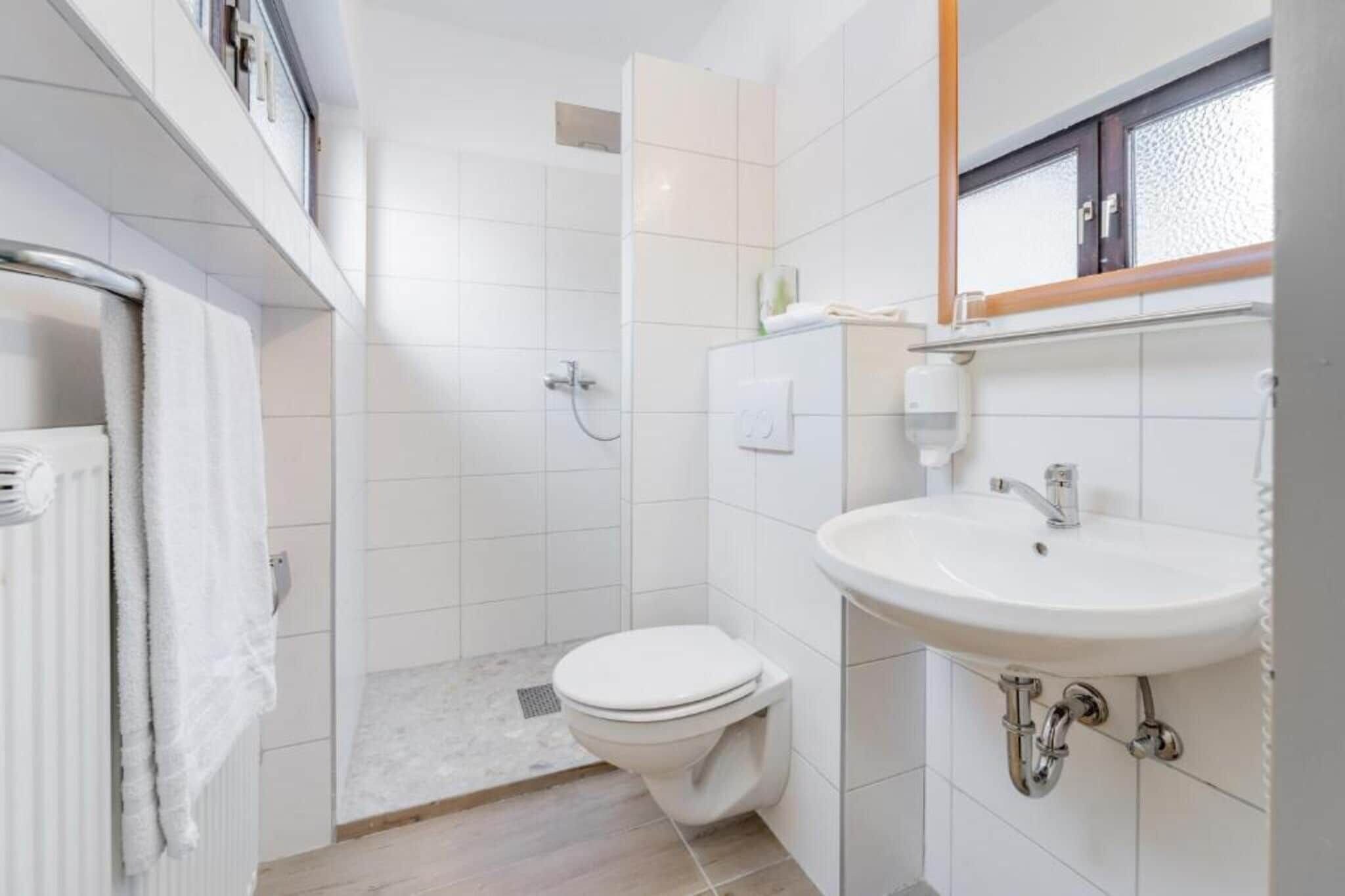 A modern bathroom with a toilet, sink, and shower.