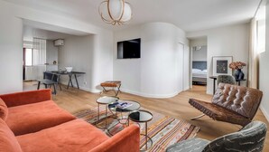 A modern living room with a sofa, coffee table, and a television. - Spacious Apartment  a/c 1BR/4P - Notre-Dame (Paris)