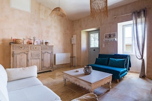 Un salon comprenant un canapé, une table basse, un meuble et un divan bleu.