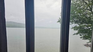 Vista de un lago tranquilo con un muro de piedra y una terraza de madera al frente.