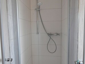 A shower with a handheld showerhead and a fixed wall-mounted faucet. - Pithan Vacation Home - Pithan House in Werdum – Vacation home with a garden, Wi-Fi, and 4 (Werdum)