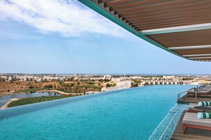 A swimming pool with a view of a cityscape and a beach.