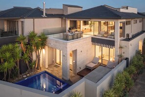 A modern two-story house with a rooftop patio, a swimming pool, and a well-maintained garden. - Bella Vista | Pool, spa & bay views (Mornington)