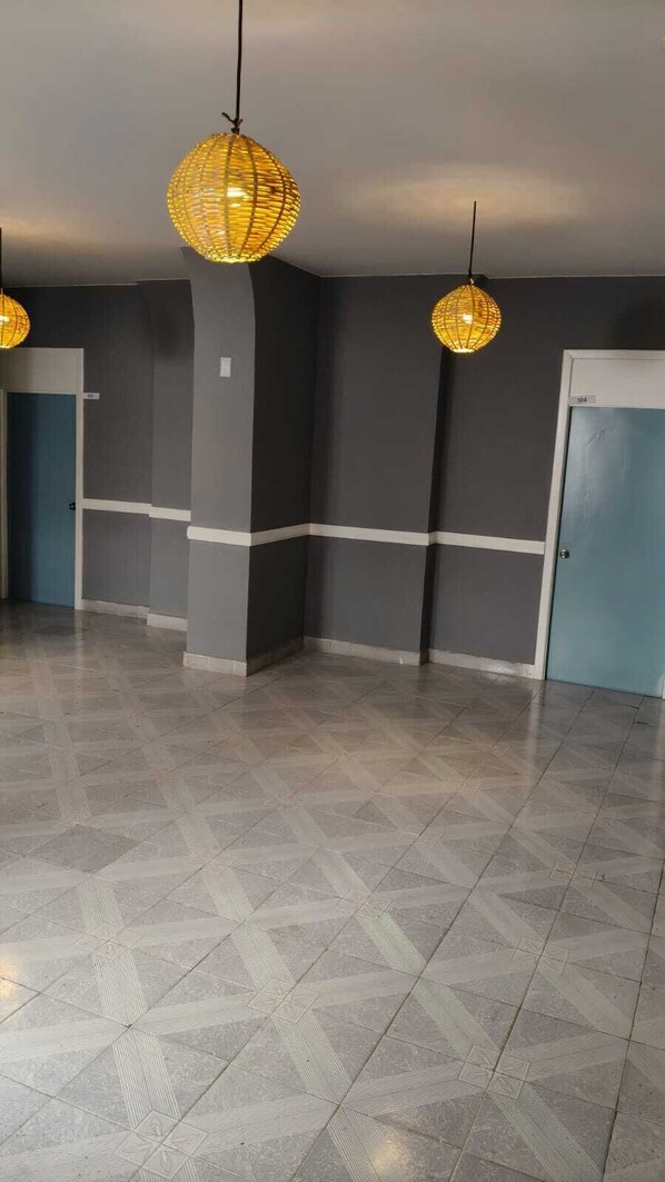 A hallway with patterned flooring, dark walls, and hanging spherical light fixtures. - Hotel Santaner Veracruz Centro Historico (Veracruz)