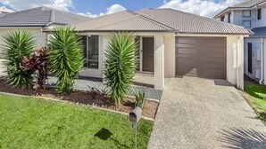 A single-story house with a garage, a front lawn with a mailbox, and a clear sky. - Tennela Haven North Lakes (North Lakes)