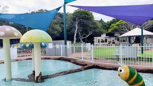 A water play area with colorful mushroom-shaped structures and a caterpillar decoration. - Tennela Haven North Lakes (North Lakes)