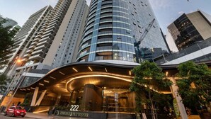 Un hotel moderno con una entrada curva, número 222, y un llamativo frente de vidrio.