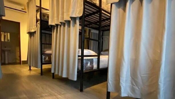 A room with bunk beds, white curtains, and a wooden floor. - Hide and Seek Hostel Vientiane (Thai Embassy) (Vientiane)