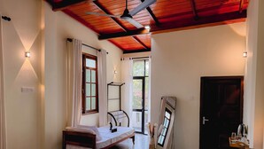 A bedroom with a bed, a bedside table, a mirror, a window with curtains, a ceiling fan, and a door. - Chill Tangalle (Tangalle)