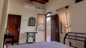 A room with a bed, a sewing machine, a table, a window, and a door. - Chill Tangalle (Tangalle)