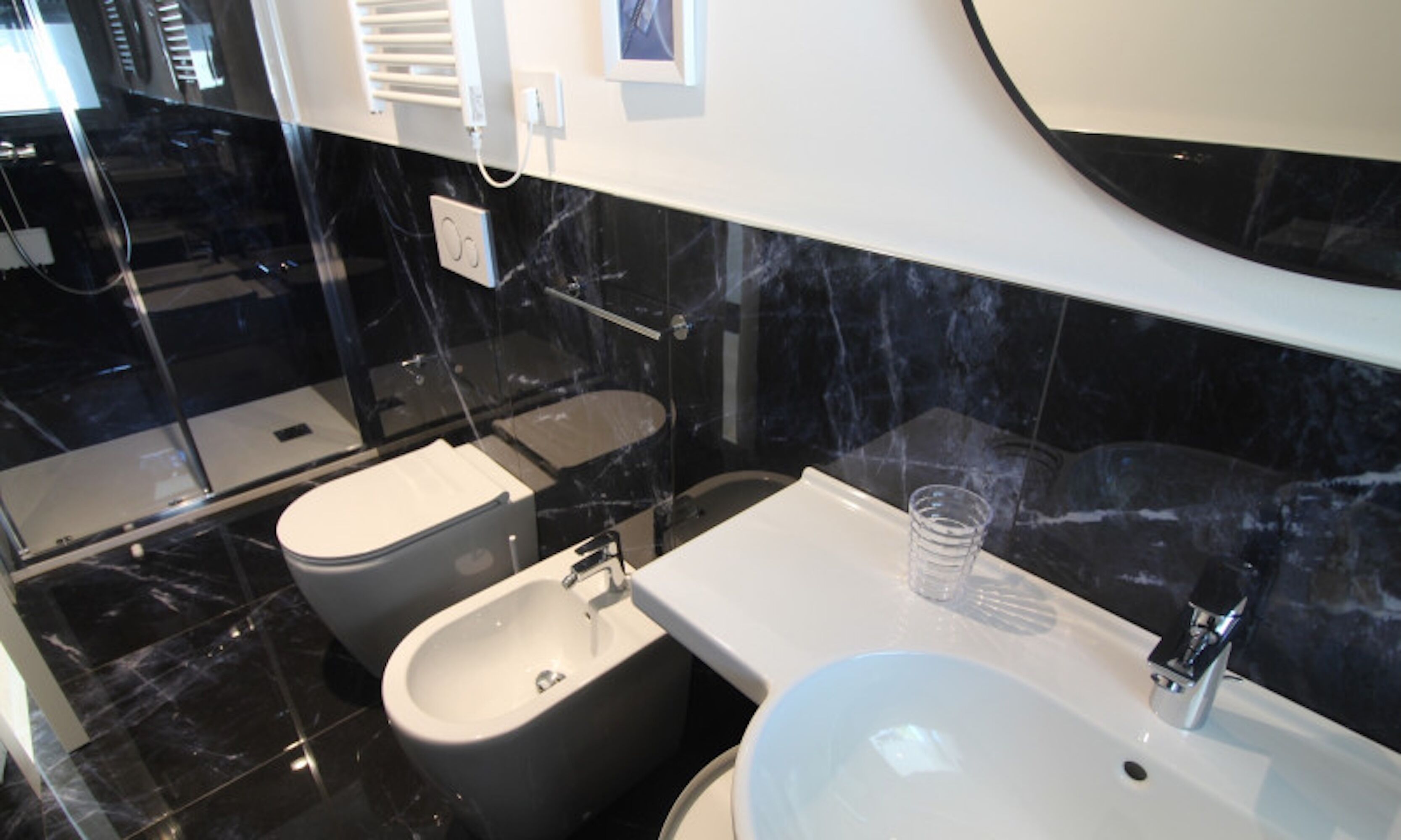 A modern bathroom with a bidet, toilet, and sink.