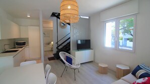 Un appartement moderne comprenant une cuisine, un coin repas, un salon et un escalier.