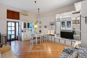 Amplia sala de estar con una mesa de comedor, sillas, sofá y televisor.