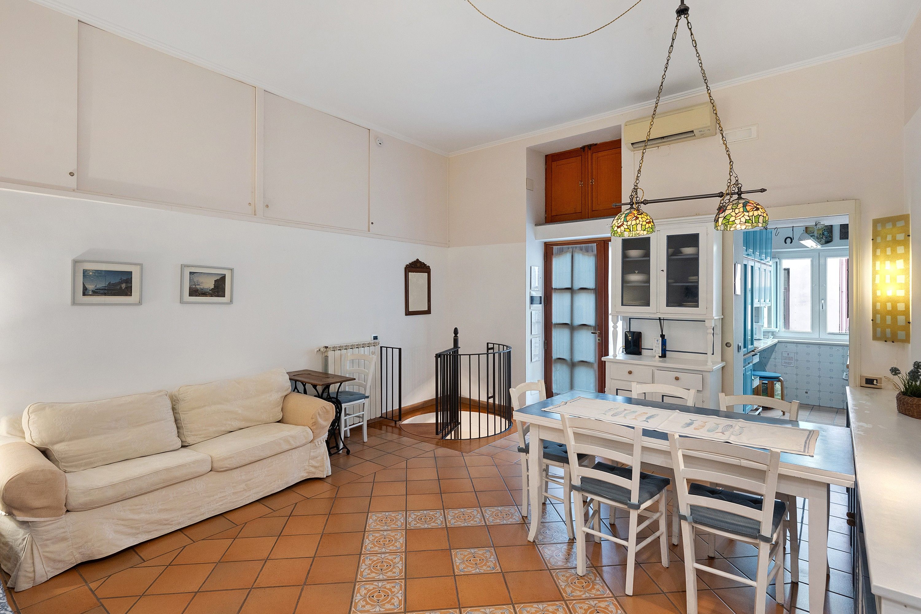 A compact living space with a kitchenette, a dining area, and a sofa.