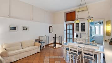 A compact living space with a kitchenette, a dining area, and a sofa.