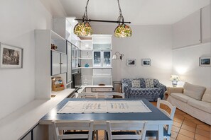 Un comedor con una mesa, sillas y una lámpara colgante.