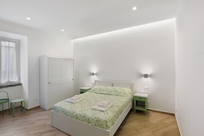 A bedroom with a bed, a wardrobe, a desk, and a chair. - Holiday Home 'Domus Mediterranea' with Wi-Fi and Air Conditioning (Sorrento)
