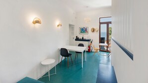Un interior moderno con comedor, escritorio y vista por una puerta.