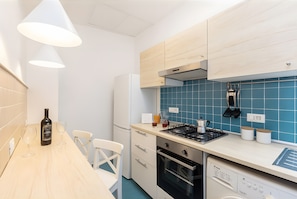 A modern kitchen with a wooden countertop, a built-in oven, a dishwasher, and a stove. - Apartment 'Annabella' with Sea View, Wi-Fi and Air Conditioning (Sorrento)