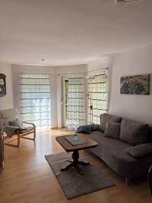 A living room with a sofa, armchair, wooden coffee table, and a floor lamp. - Enjoy a vacation on the edge of Saxon Switzerland (Dürrröhrsdorf-Dittersbach)