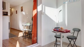 Un coin repas avec une table, des chaises et un plateau rouge contenant de la nourriture.