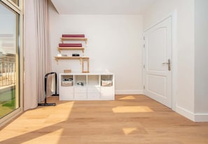 A room with a wooden floor, a white door, a window with curtains, and a white storage unit with shelves. - Al Furjan Villa WPrivate Pool & Gym Near Marina (Dubai)