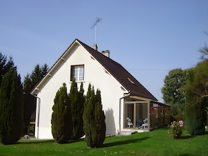 A single-story house with a sloped roof, a chimney, and a window.