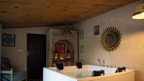 A bathroom with a bathtub, a sink, a mirror, and a decorative wall piece. - Bhanpur Haveli | Hidden Luxury Haveli Amid Greenery & Peace (Jamwa Ramgarh)