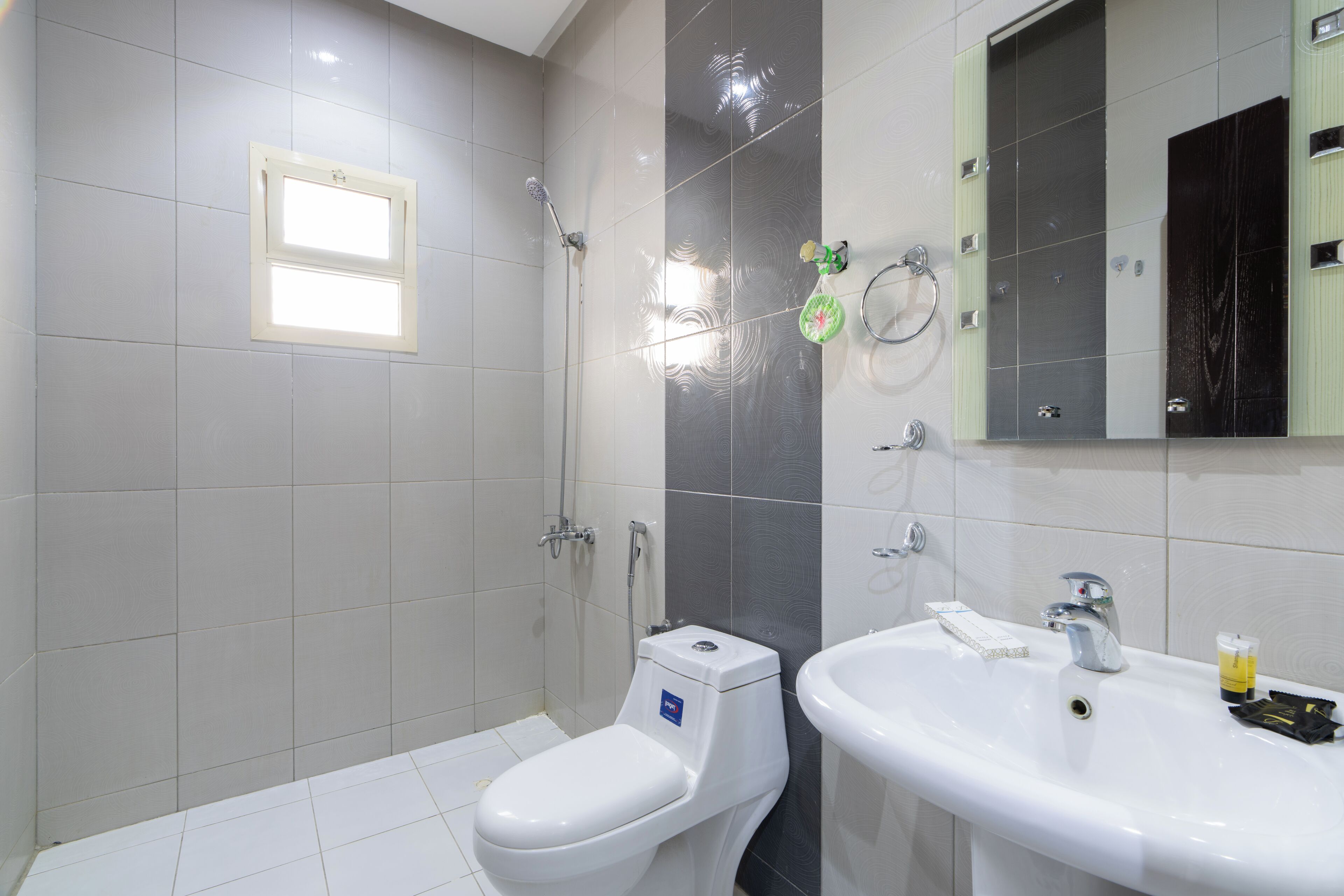 A modern bathroom with a toilet, shower, and sink.