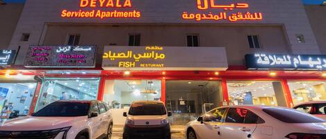 A building with signs for 'DEYALA Serviced Apartments' and 'Fish Restaurant'.