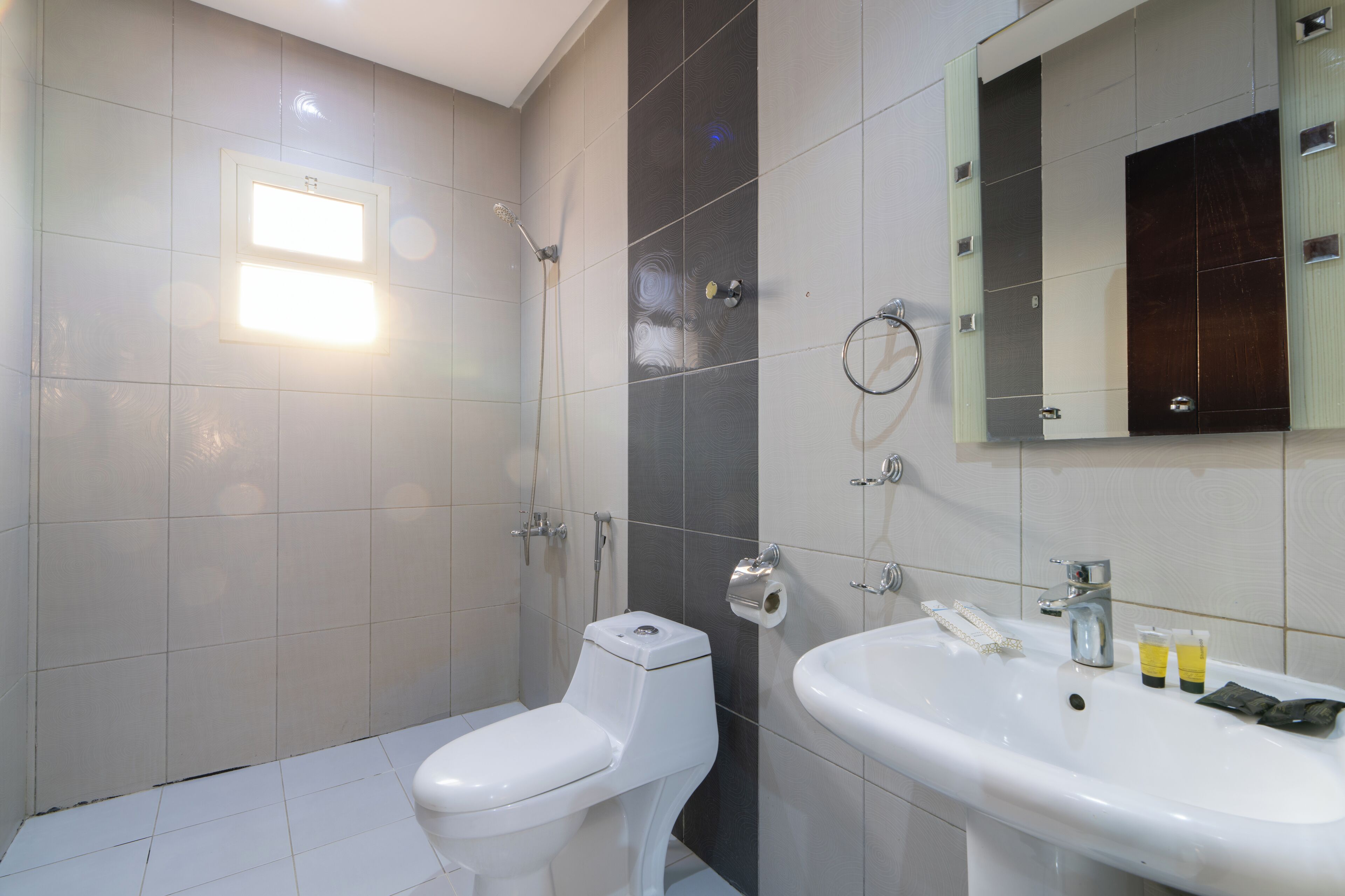 A modern bathroom with a toilet, shower, and sink.