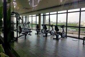 Una sala de gimnàstica amb equipament esportiu i grans finestres.