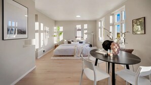 A modern bedroom with a bed, bedside tables, and a window with a view.