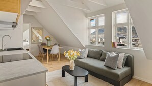 A modern loft apartment with a kitchen, dining area, and a living room with a view of the city.
