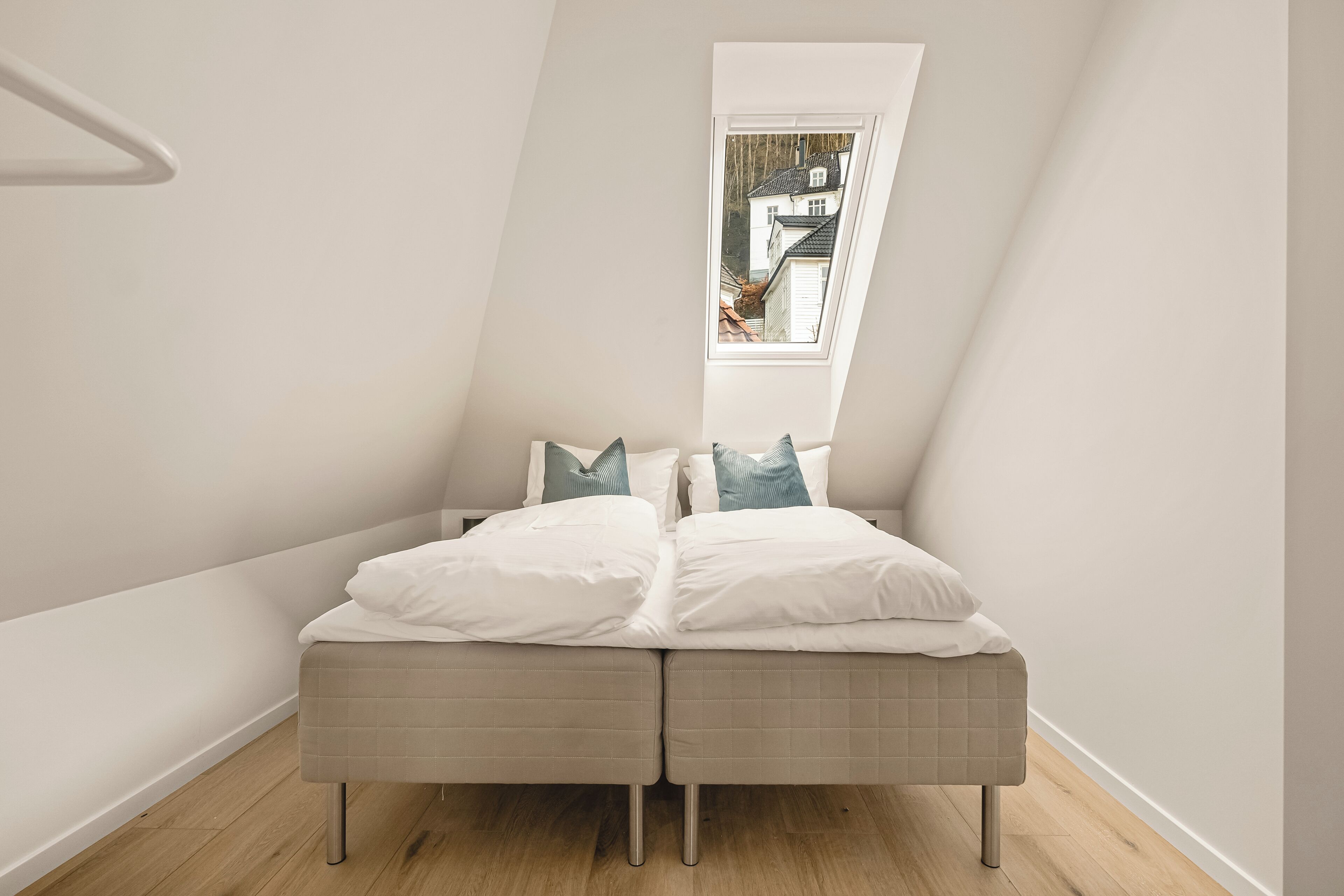 Une chambre à coucher avec un lit, des oreillers et une fenêtre.
