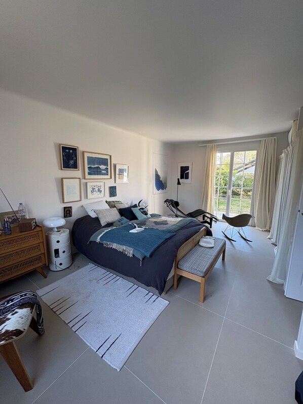 A modern bedroom with a large bed, bedside tables, a dresser, a rocking chair, and a window with curtains. - ✨ Villa Aterpéa - Luxury, Nature, Golf & Art of living in Hossegor ✨ (Capbreton)