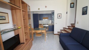 A compact living space with a dining area, kitchenette, and a sofa. - Villa 500mt From the Beach (Lignano Sabbiadoro)