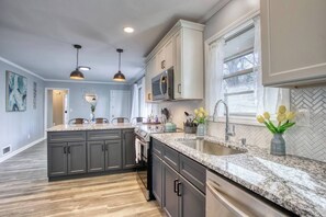 A modern kitchen with granite countertops, dark cabinets, and pendant lighting. - This house is a 3 bedroom(s), 2 bathrooms, located in Decatur, GA. (Decatur)