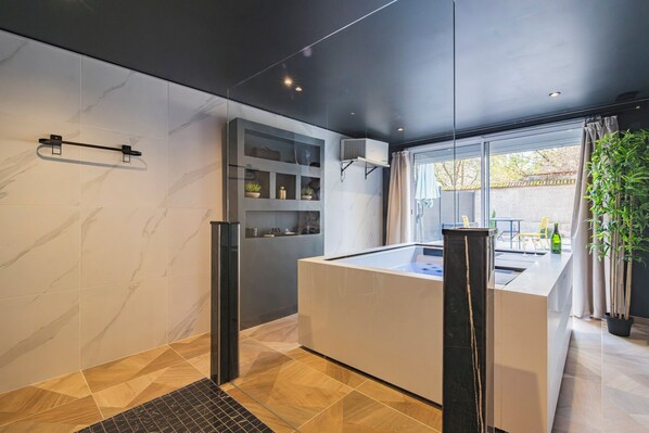 Cocina moderna con una isla central, estanterías empotradas y un amplio ventanal con vistas al exterior.
