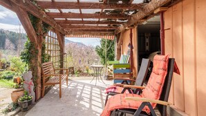 A covered patio with wooden chairs, a table, and a view of a mountainous landscape. - Apartment 'Haus Gertrud' with Mountain View, Shared Terrace, and Wi-Fi (Bühl)
