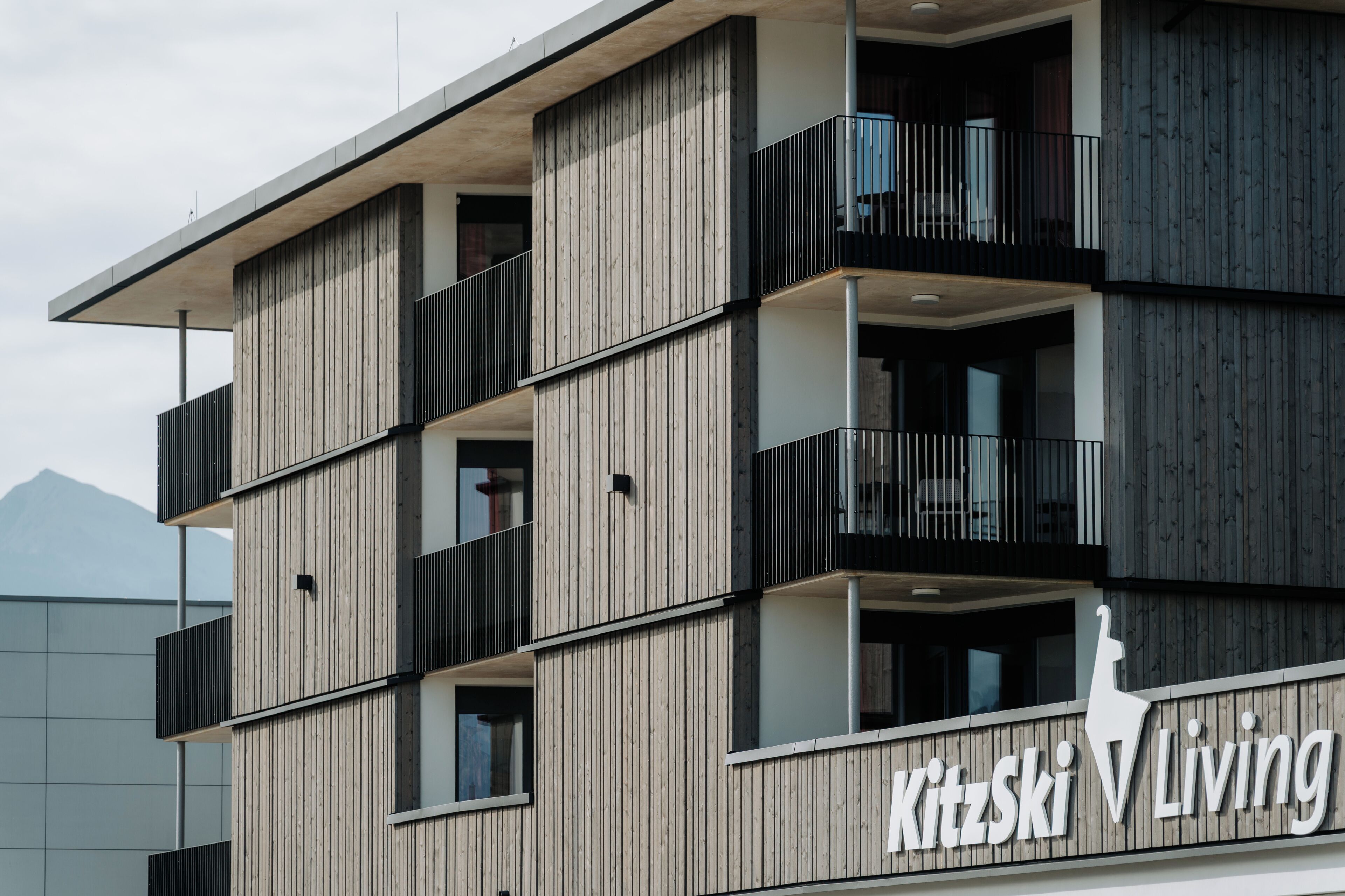Ein mehrstöckiges Gebäude mit einer Holzfassade und Balkonen.