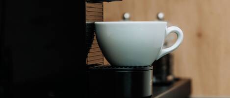Una macchina del caffè con una tazza appoggiata sopra.